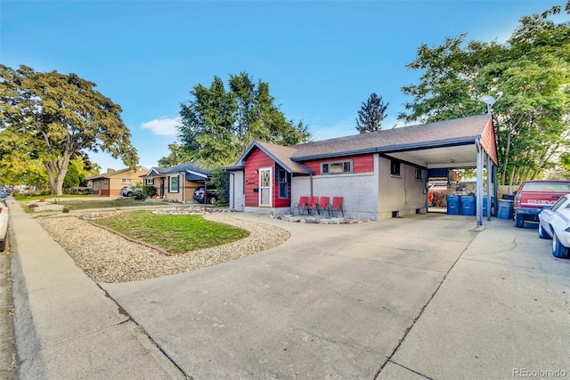 ranch-style house featuring a front yard, an attached carport, and concrete driveway