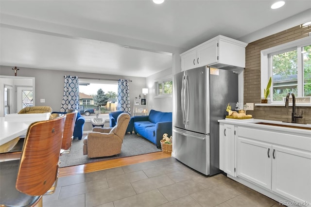 kitchen with plenty of natural light, freestanding refrigerator, a sink, and open floor plan