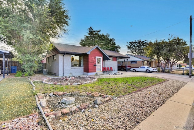 view of front facade featuring fence, a front yard, driveway, and brick siding