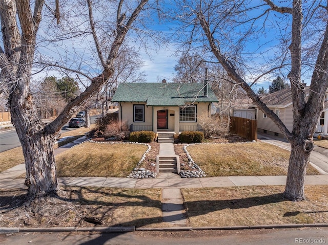 view of front facade featuring roof with shingles and stucco siding