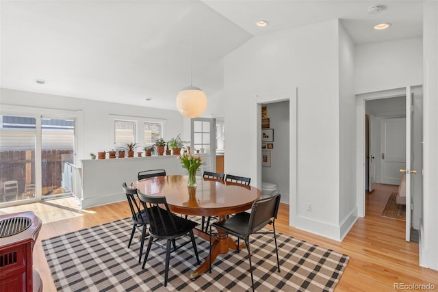 dining room featuring high vaulted ceiling, light wood-style flooring, baseboards, and recessed lighting