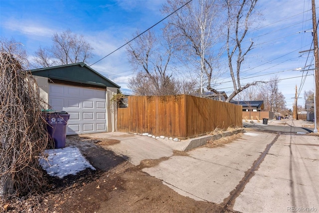 detached garage with driveway and fence