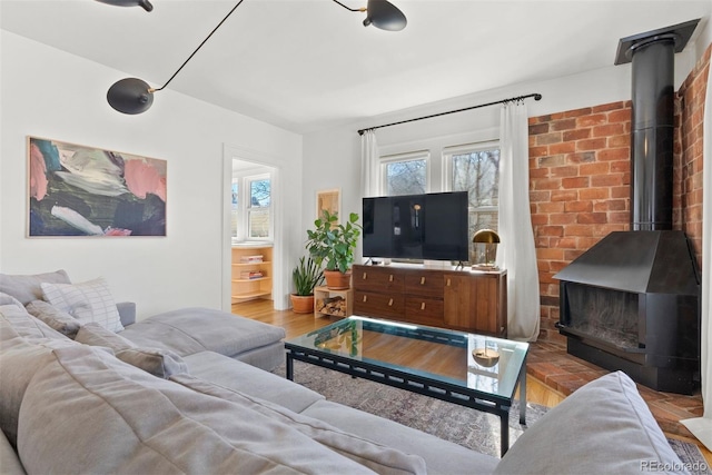 living area with wood finished floors and a wood stove