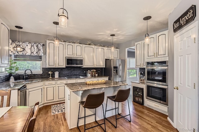 10330 Lions Path, Lone Tree, CO 80124 - kitchen with stainless steel appliances, a sink, beverage cooler, backsplash, and dark stone counters