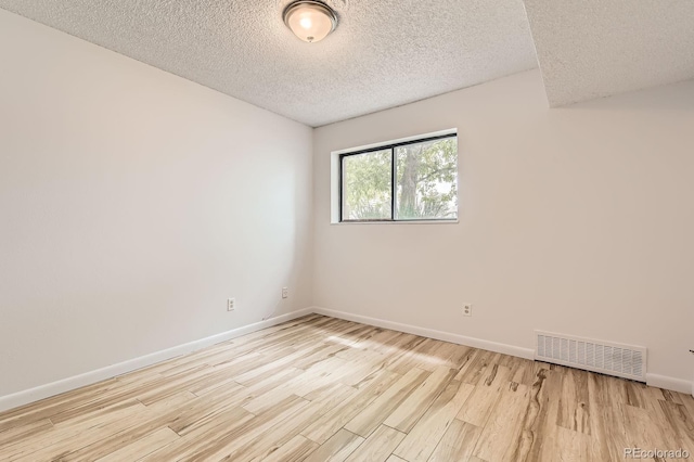 7665 E Eastman Ave Unit 111A, Denver, CO 80231 - empty room with light wood finished floors, baseboards, and a textured ceiling