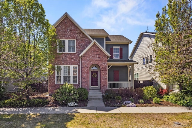 traditional-style home featuring a porch and brick siding