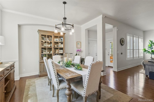dining area with baseboards, a notable chandelier, dark wood finished floors, and ornamental molding