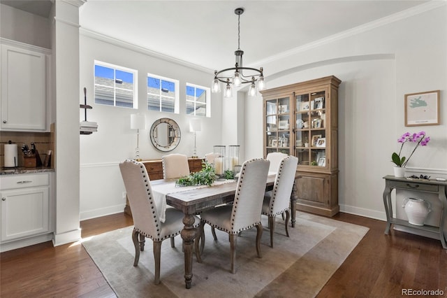 dining space with baseboards, an inviting chandelier, crown molding, and dark wood-style floors