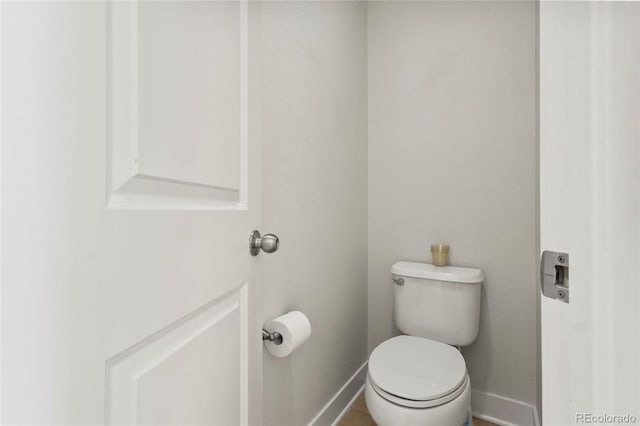 bathroom with toilet and baseboards