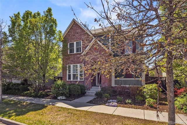 traditional home with covered porch and brick siding