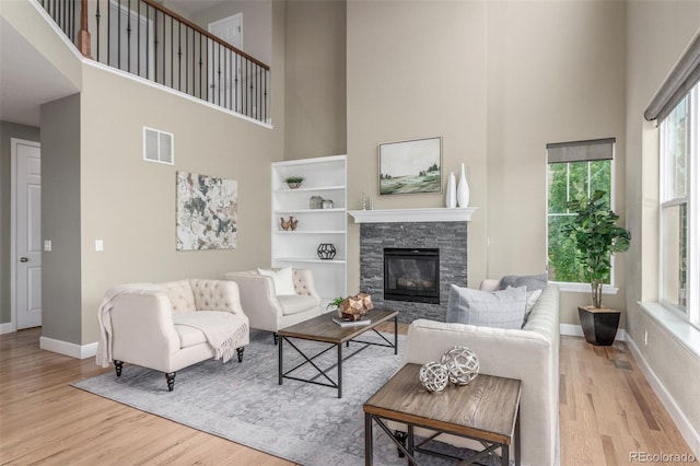 676 Fossil Bed Cir, Erie, CO 80516 - living room featuring a towering ceiling, wood finished floors, baseboards, and healthy amount of natural light