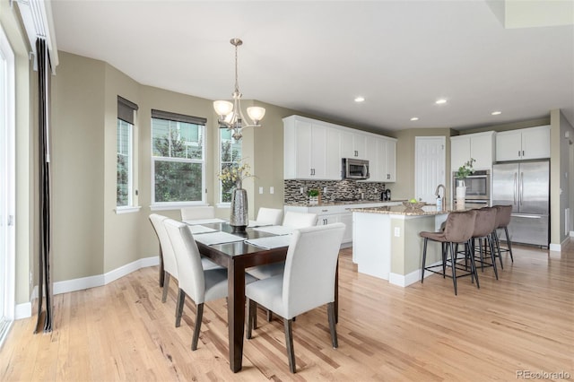 676 Fossil Bed Cir, Erie, CO 80516 - dining room with a chandelier, baseboards, light wood finished floors, and recessed lighting
