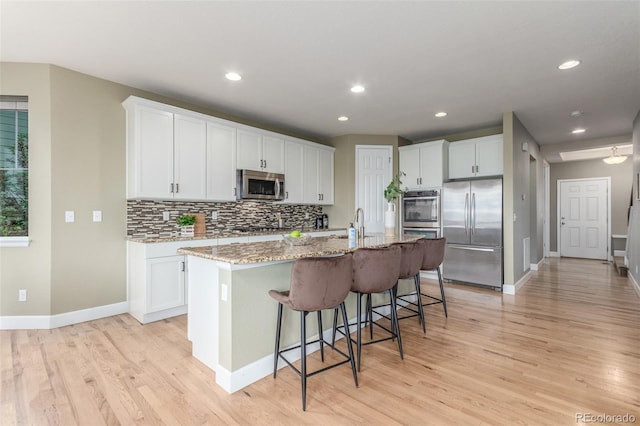 676 Fossil Bed Cir, Erie, CO 80516 - kitchen with appliances with stainless steel finishes, baseboards, light wood-style floors, and recessed lighting