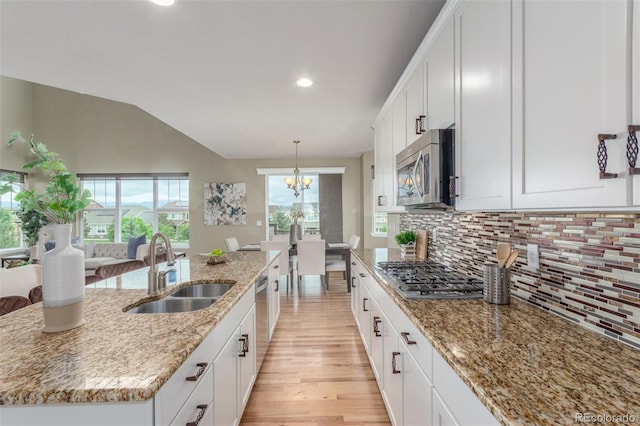 676 Fossil Bed Cir, Erie, CO 80516 - kitchen with appliances with stainless steel finishes, a sink, decorative backsplash, light wood-style floors, and light stone counters