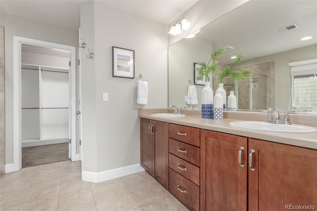676 Fossil Bed Cir, Erie, CO 80516 - full bath with double vanity, a shower stall, a walk in closet, baseboards, and tile patterned floors
