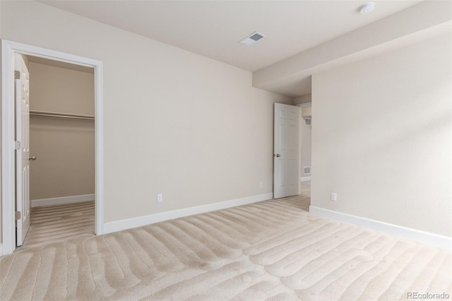 676 Fossil Bed Cir, Erie, CO 80516 - unfurnished bedroom featuring light carpet, a walk in closet, and baseboards