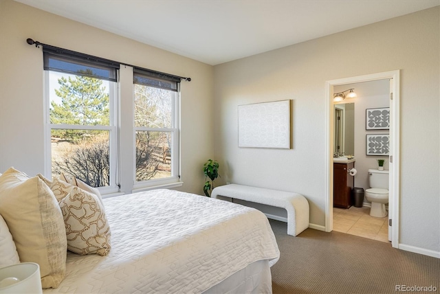 carpeted bedroom with baseboards and connected bathroom