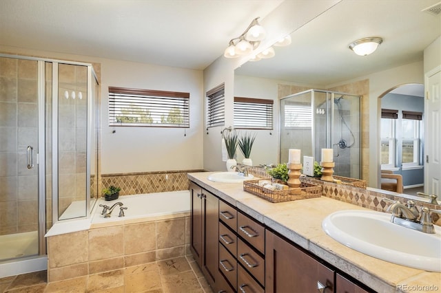 bathroom with a bath, a shower stall, and a sink