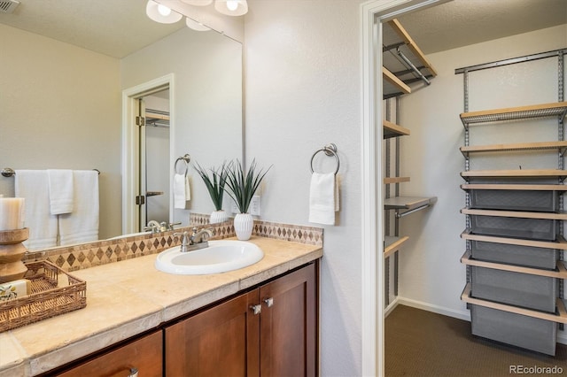 bathroom featuring visible vents, vanity, and baseboards