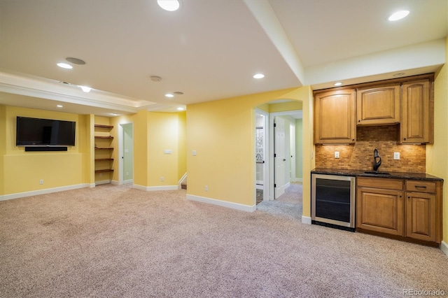 interior space featuring arched walkways, decorative backsplash, light colored carpet, wine cooler, and open floor plan