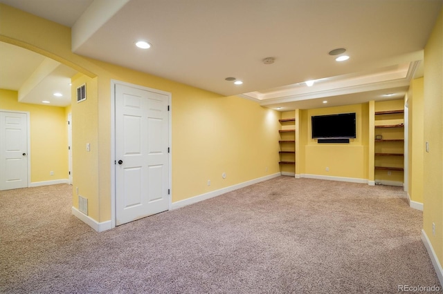 finished below grade area featuring arched walkways, baseboards, carpet flooring, and recessed lighting