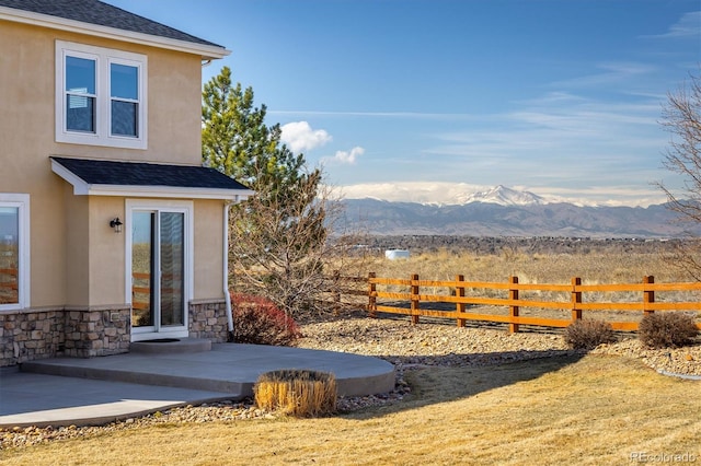 view of yard with a patio area, a mountain view, and fence