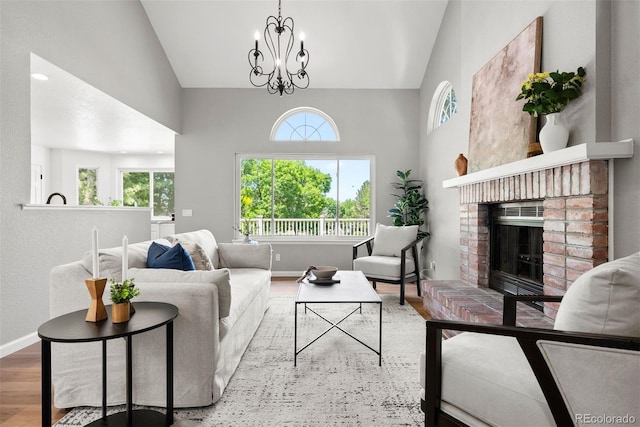 1473 E 130th Dr, Thornton, CO 80241 - living room featuring healthy amount of natural light, high vaulted ceiling, a brick fireplace, a chandelier, and wood finished floors