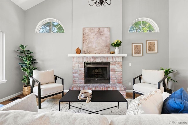 1473 E 130th Dr, Thornton, CO 80241 - living area featuring plenty of natural light, wood finished floors, high vaulted ceiling, and a fireplace