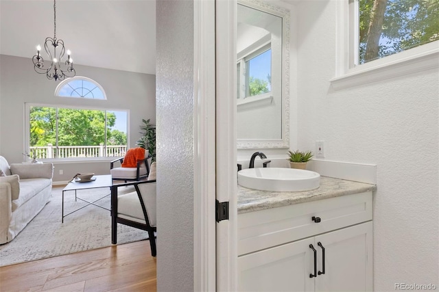 1473 E 130th Dr, Thornton, CO 80241 - bathroom featuring vanity, wood finished floors, a textured wall, and a chandelier