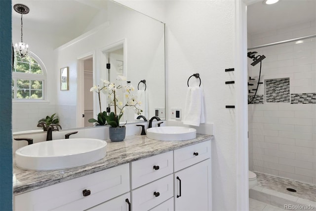 1473 E 130th Dr, Thornton, CO 80241 - bathroom with double vanity, a tile shower, and a chandelier