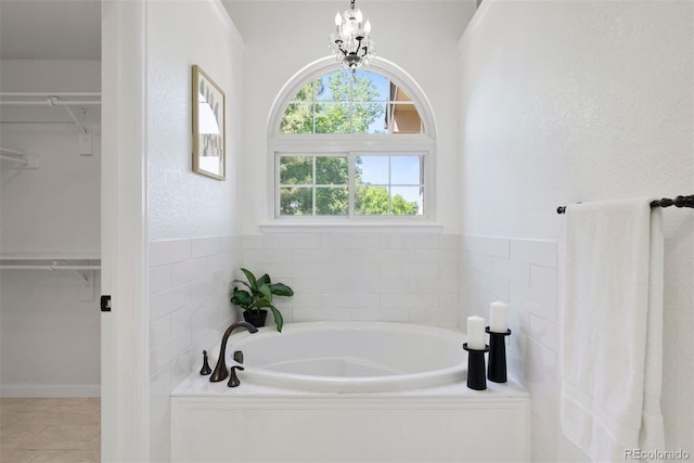 1473 E 130th Dr, Thornton, CO 80241 - bathroom featuring a spacious closet, a bath, and a chandelier