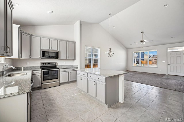 kitchen featuring a kitchen island, a sink, open floor plan, appliances with stainless steel finishes, and gray cabinets