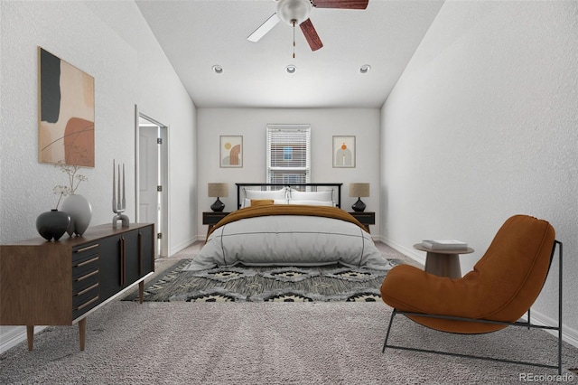 bedroom with ceiling fan, a textured wall, carpet, and baseboards