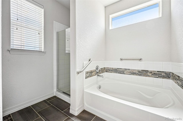 full bathroom with a stall shower, tile patterned flooring, baseboards, and a bath