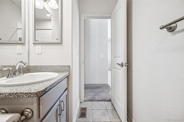 bathroom featuring visible vents, a textured wall, vanity, and tile patterned floors