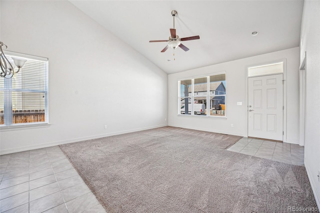 unfurnished living room with baseboards, carpet flooring, a ceiling fan, and tile patterned floors