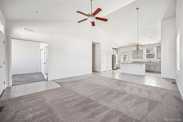 unfurnished living room featuring high vaulted ceiling, visible vents, light tile patterned flooring, and light colored carpet