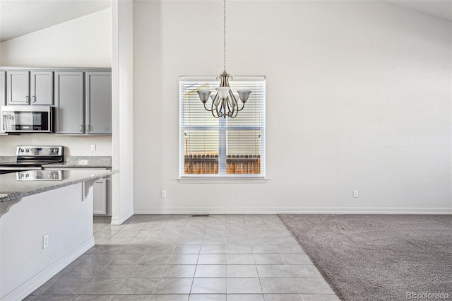 kitchen featuring pendant lighting, gray cabinetry, an inviting chandelier, appliances with stainless steel finishes, and light stone countertops