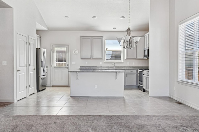 kitchen with appliances with stainless steel finishes, gray cabinets, and light colored carpet