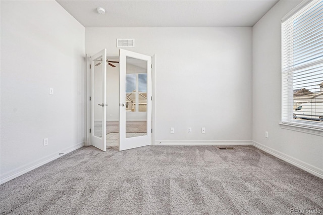 unfurnished bedroom featuring multiple windows, carpet flooring, and visible vents