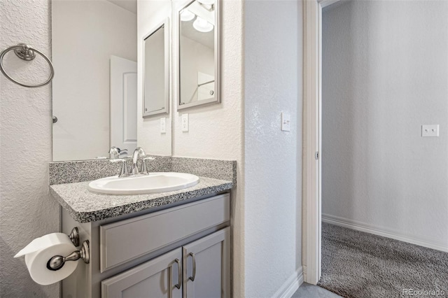 bathroom with a textured wall and vanity