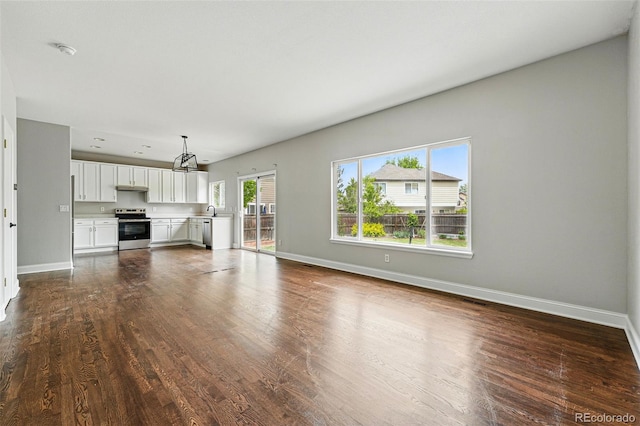 1248 Button Rock Dr, Longmont, CO 80504 - unfurnished living room with baseboards, a sink, and dark wood-style flooring