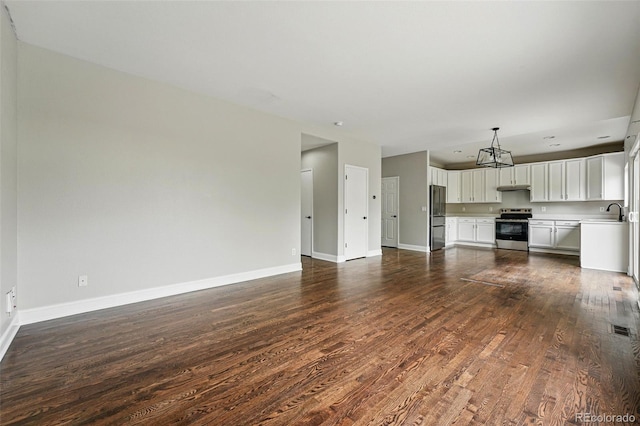 1248 Button Rock Dr, Longmont, CO 80504 - unfurnished living room with dark wood finished floors, baseboards, and a chandelier