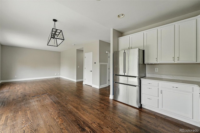 1248 Button Rock Dr, Longmont, CO 80504 - kitchen with freestanding refrigerator, white cabinetry, dark wood finished floors, and baseboards