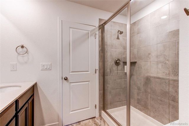 bathroom featuring a shower with door and vanity