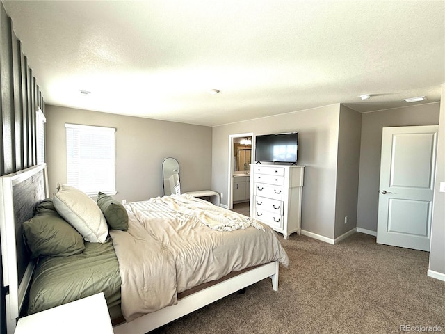 bedroom with ensuite bath, a textured ceiling, and carpet flooring