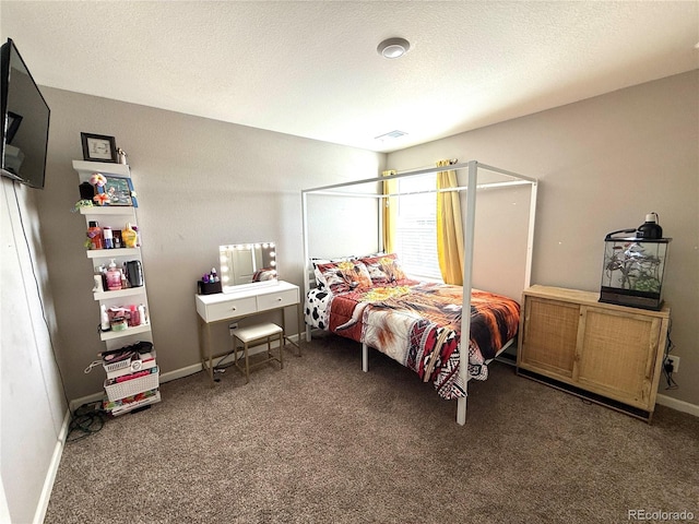 bedroom with a textured ceiling and dark carpet