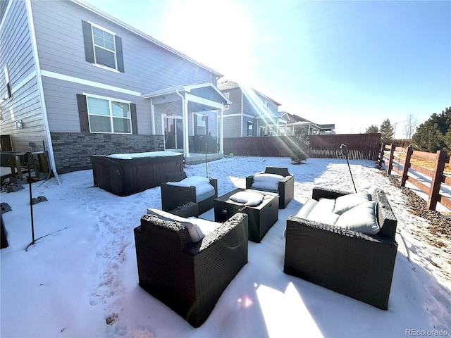 snow covered patio featuring a hot tub and outdoor lounge area