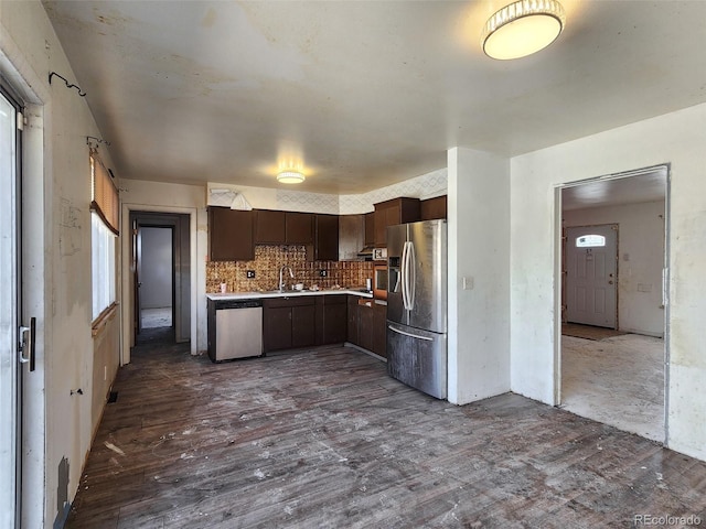 kitchen featuring backsplash, dark wood finished floors, dark brown cabinetry, appliances with stainless steel finishes, and light countertops