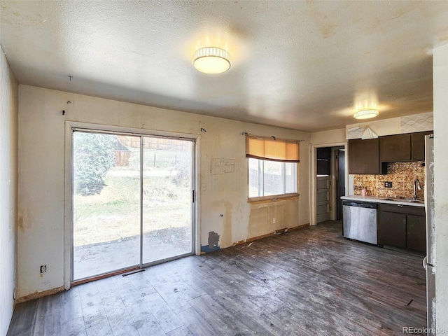 kitchen with dark wood-style floors, a sink, decorative backsplash, dark brown cabinets, and dishwasher